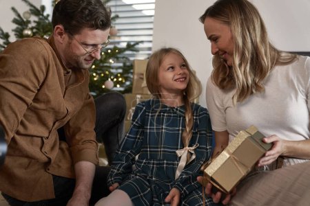 Téléchargez les photos : Partage de cadeaux de Noël en famille dans la maison - en image libre de droit