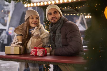 Téléchargez les photos : Couple caucasien s'amuser sur le marché de Noël - en image libre de droit