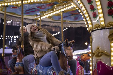 Téléchargez les photos : Couple s'amuser sur le carrousel - en image libre de droit