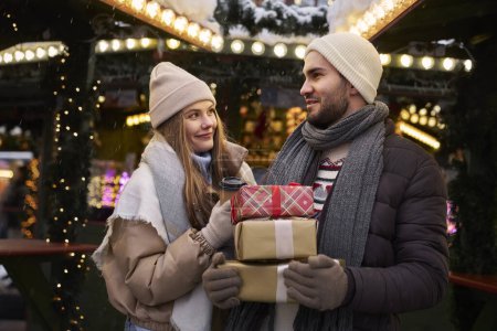 Téléchargez les photos : Couple caucasien sur le marché de Noël avec cadeaux de Noël - en image libre de droit