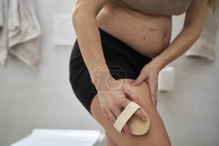 Photo for Pregnant woman doing dry body brushing - Royalty Free Image