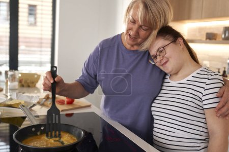 Foto de Síndrome de Down mujer y su madre preparando el desayuno juntos - Imagen libre de derechos