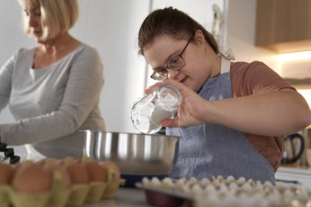 Photo for Down syndrome woman and her mother baking together - Royalty Free Image