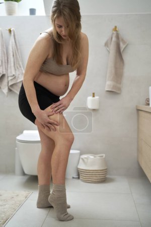 Foto de Mujer embarazada comprobando la condición de la piel - Imagen libre de derechos