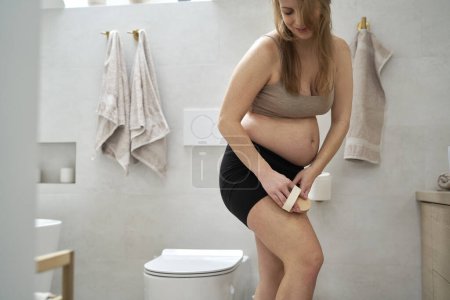 Téléchargez les photos : Femme enceinte faisant brossage du corps sec - en image libre de droit