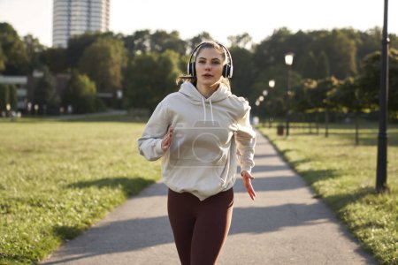 Téléchargez les photos : Jeune femme jogging dans le parc - en image libre de droit
