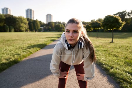 Téléchargez les photos : Jeune femme pendant le jogging dans le parc - en image libre de droit