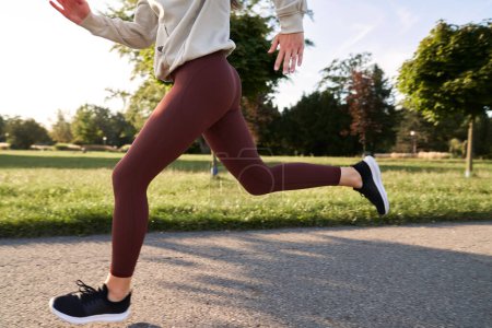 Téléchargez les photos : Gros plan d'une femme méconnaissable faisant du jogging dans le parc - en image libre de droit