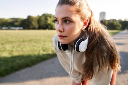 Téléchargez les photos : Jeune femme pendant le jogging dans le parc - en image libre de droit