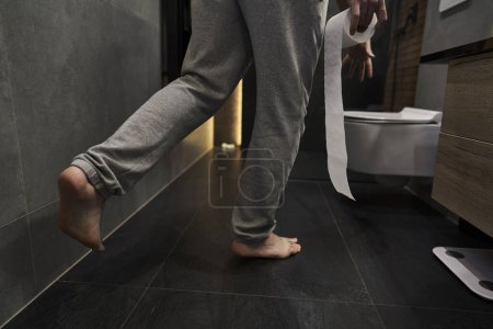 Photo for Man holding toilet paper and running towards the toilet - Royalty Free Image
