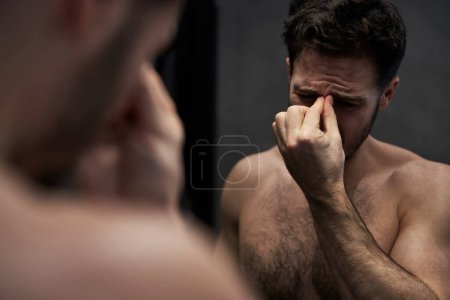 Foto de Hombre con dolor de cabeza en el baño - Imagen libre de derechos