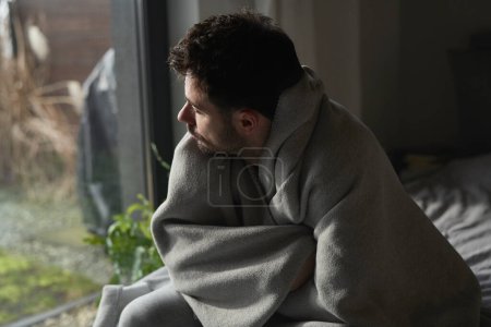 Foto de Hombre deprimido cubierto con una manta - Imagen libre de derechos
