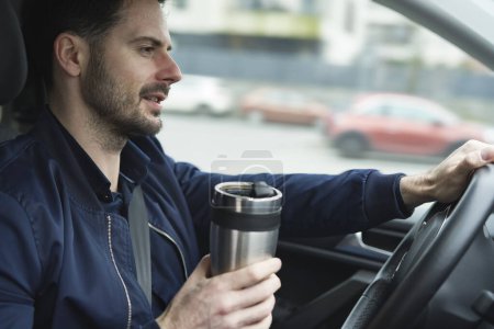 Téléchargez les photos : Homme utilisant une tasse réutilisable dans la voiture - en image libre de droit