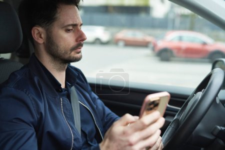 Téléchargez les photos : Homme utilisant le téléphone dans la voiture - en image libre de droit