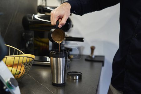 Téléchargez les photos : Homme verser du café fait maison dans la tasse de voyage - en image libre de droit