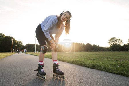Téléchargez les photos : Jeune femme se prépare pour le roller dans le parc - en image libre de droit
