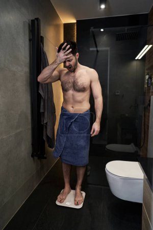 Téléchargez les photos : Homme choqué utilisant échelle de salle de bains - en image libre de droit