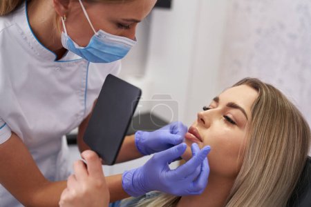 Photo for Doctor and patient before beauty procedure in beauty salon - Royalty Free Image