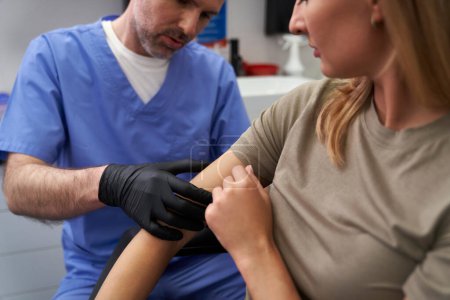 Foto de Médico marca de verificación en el brazo de la mujer - Imagen libre de derechos