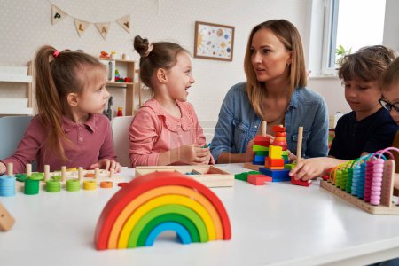 Lehrerin und Kinder bei Sinnesübungen im Kindergarten
