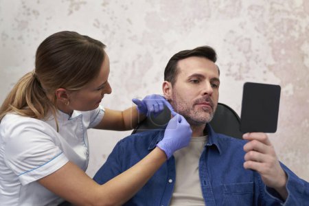 Téléchargez les photos : Médecin et patient avant la procédure de beauté dans le salon de beauté - en image libre de droit