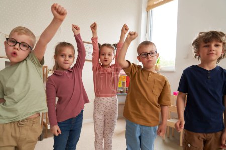 Photo for Preschool children with hands raised - Royalty Free Image