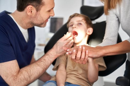 Foto de Madre apoyo hijo teniendo visita en dentista - Imagen libre de derechos
