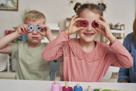 Téléchargez les photos : Petite fille et garçon s'amuser avec des jouets Montessori - en image libre de droit