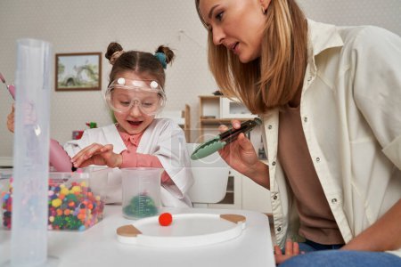 Child in lab coat having sensory exercises with a teacher
