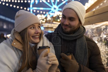 Téléchargez les photos : Couple caucasien s'amuser sur le marché de Noël - en image libre de droit