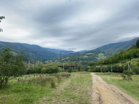Photo for Landscape with dirt road in the mountains under cloudy sky - Royalty Free Image