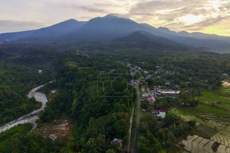 Téléchargez les photos : Vue de l'Indonésie le matin, région de village de montagne et rivière et soleil éclatant de la photographie aérienne - en image libre de droit