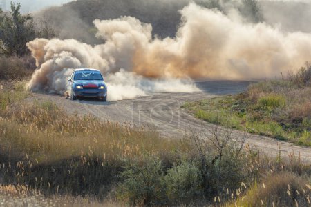 Foto de Día soleado de verano. Pista de rally polvoriento. Un coche de rally hace mucho polvo en un giro 17 - Imagen libre de derechos
