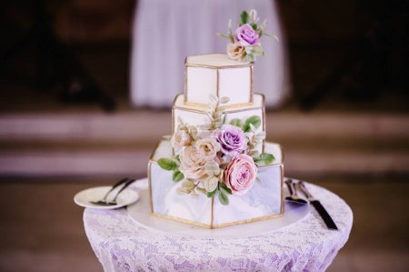 Foto de Un clásico pastel blanco y gris estratificado con decoración de flores y patrón geométrico. Un pastel de bodas. - Imagen libre de derechos