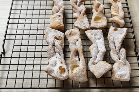 Téléchargez les photos : Fat Thursday Celebration - biscuits traditionnels Angel Wings décorés avec du sucre en poudre. Dessert de fête - en image libre de droit