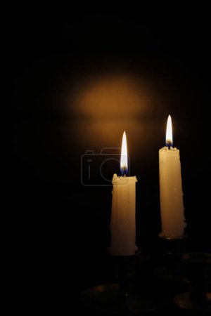 Téléchargez les photos : Deux bougies et un éclairage spectaculaire sur fond de bois brun. Ressources graphiques - en image libre de droit