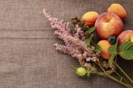 Foto de Planta de astillbe rosa y mezcla de frutas sobre la mesa. Recursos gráficos - Imagen libre de derechos