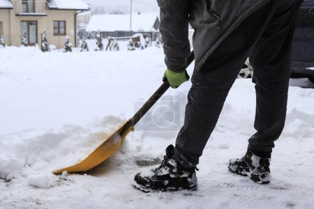 Photo for Man removing snow from the sidewalk after snowstorm. Winter time - Royalty Free Image