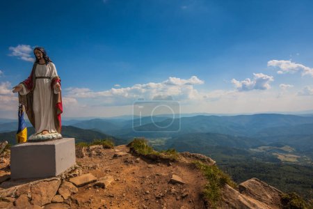 Photo for Jesus statue on top of a mountain. Beautiful view of the Ukrainian Carpathians to the mountains and valleys. Rain clouds in the mountains. Yellow and green grass, and the top of the mountain. - Royalty Free Image