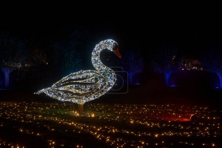 Téléchargez les photos : Un cygne illuminé fait de lumières de fées à l'installation de lumière Lumagica dans le parc Elbauenburg à Magdebourg pour mettre l'ambiance pour la saison de Noël - en image libre de droit