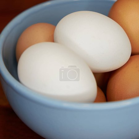 Foto de Fresh brown and white eggs in a bowl on a kitchen table - Imagen libre de derechos