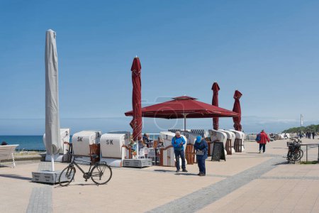 Photo for Kuehlungsborn, Germany  May 24, 2023: Holidaymakers at a cafe on the beach promenade of Kuehlungsborn on the German Baltic Sea coast - Royalty Free Image