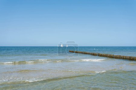 Photo for Sea landscape near Khlungsborn on the German Baltic Sea coast with breakwaters and sailboats on the horizon - Royalty Free Image