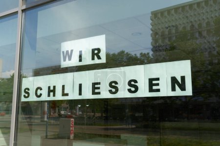 Photo for Sign with the german inscription wir schliessen on the window of a store in Magdeburg. Translation: we close - Royalty Free Image
