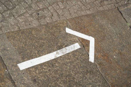 Photo for White marker made of tape on a footpath in the city center of Berlin as a signpost to an event - Royalty Free Image