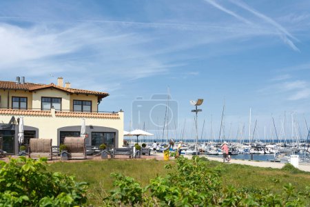 Photo for Kuehlungsborn, Germany  May 22, 2023: Kuehlungsborn beach promenade with restaurants and ships in the harbor on the German Baltic Sea coast - Royalty Free Image