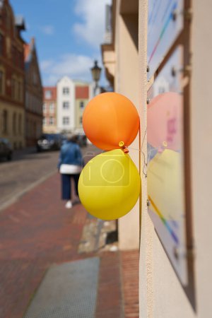 Photo for Balloons indicating a company anniversary on the facade of a commercial building in the old town of Wismar in Germany - Royalty Free Image