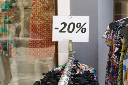    Avis de 20 pour cent de réduction sur les vêtements dans un magasin dans la vieille ville de Riva del Garda en Italie                            