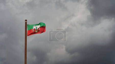 Photo for Flag with the city arms of Magdeburg in Germany in front of a gloomy sky, which is supposed to represent the financial problems with text free space on the right side - Royalty Free Image