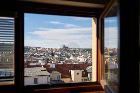 Foto de Vista a través de la ventana abierta de una habitación de hotel sobre el casco antiguo de Praga con el Castillo de Praga - Imagen libre de derechos